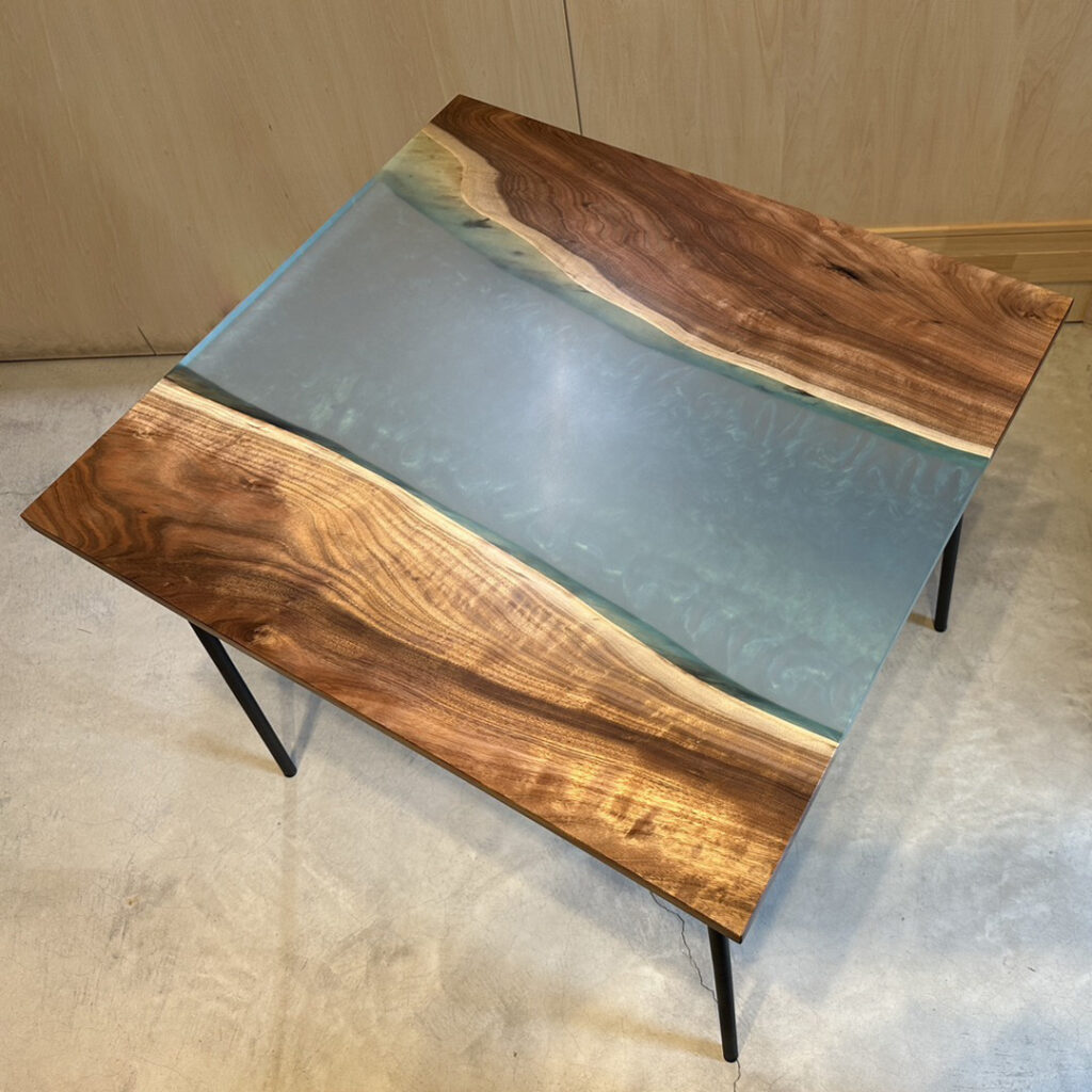 ブルーの波紋模様が入ったスモークカラーのレジンと、美しい木目の無垢材を組み合わせたスクエアテーブル