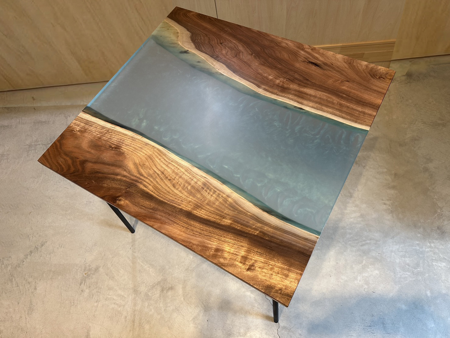 濃淡のあるウッドパーツの間に、神秘的な水色のレジンを流し込んだテーブルの天板俯瞰写真